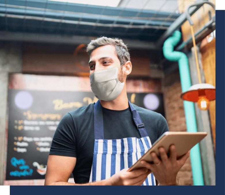Restaurant owner wearing mask and holding tablet
