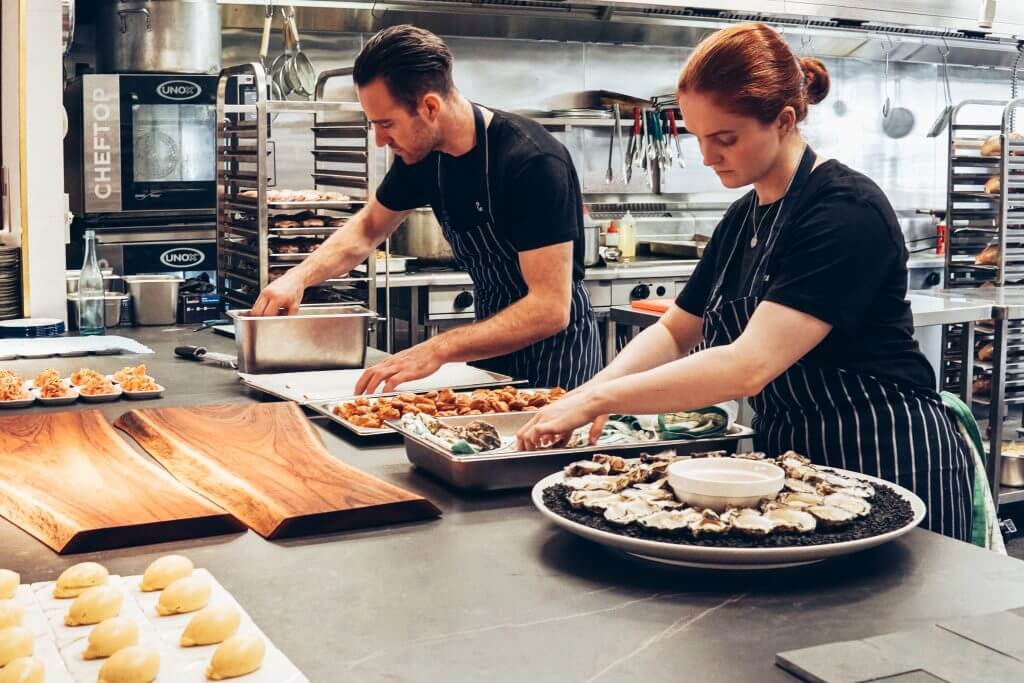 man and woman in kitchen preparing food